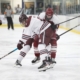 Two hockey players battle for the puck