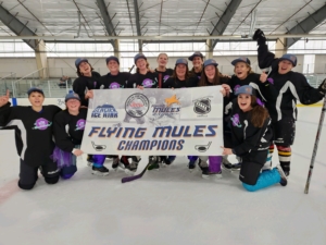 Women's hockey team posing with championship banner